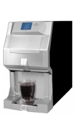 A silver automatic coffee machine dispenses coffee into a clear glass mug placed on its tray.