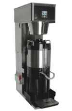 Commercial coffee brewing machine with a stainless steel exterior and a black carafe positioned under the dispenser.
