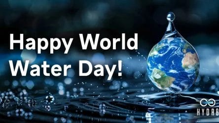 Text reads "Happy World Water Day!" next to a large water droplet containing an image of Earth, set against a blurred water surface with droplets. HYDR8 logo is at the bottom right.