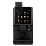 A black coffee vending machine with a touchscreen display showing various coffee options and a cup dispenser at the bottom.